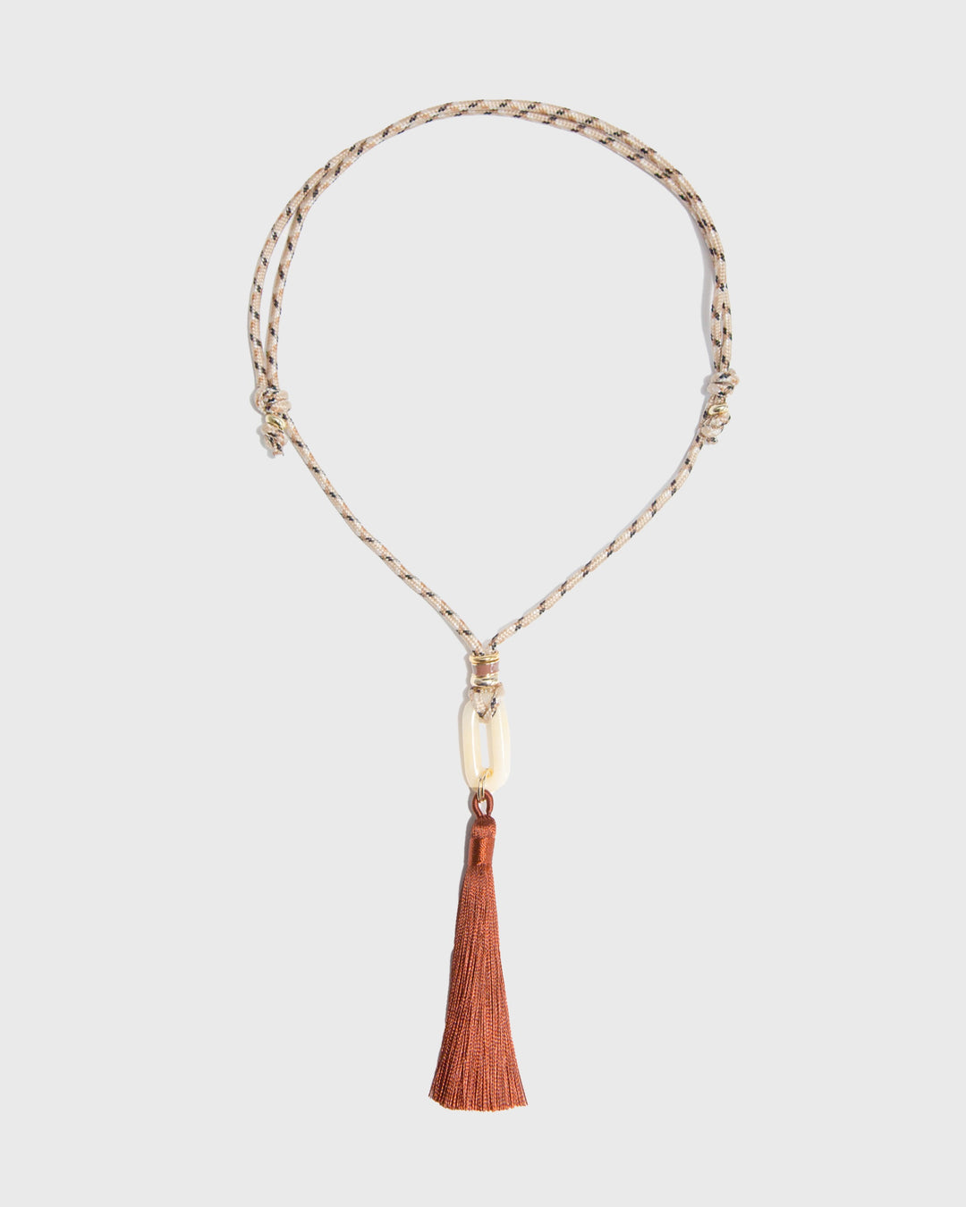 Necklace with a tassel on a light gray background