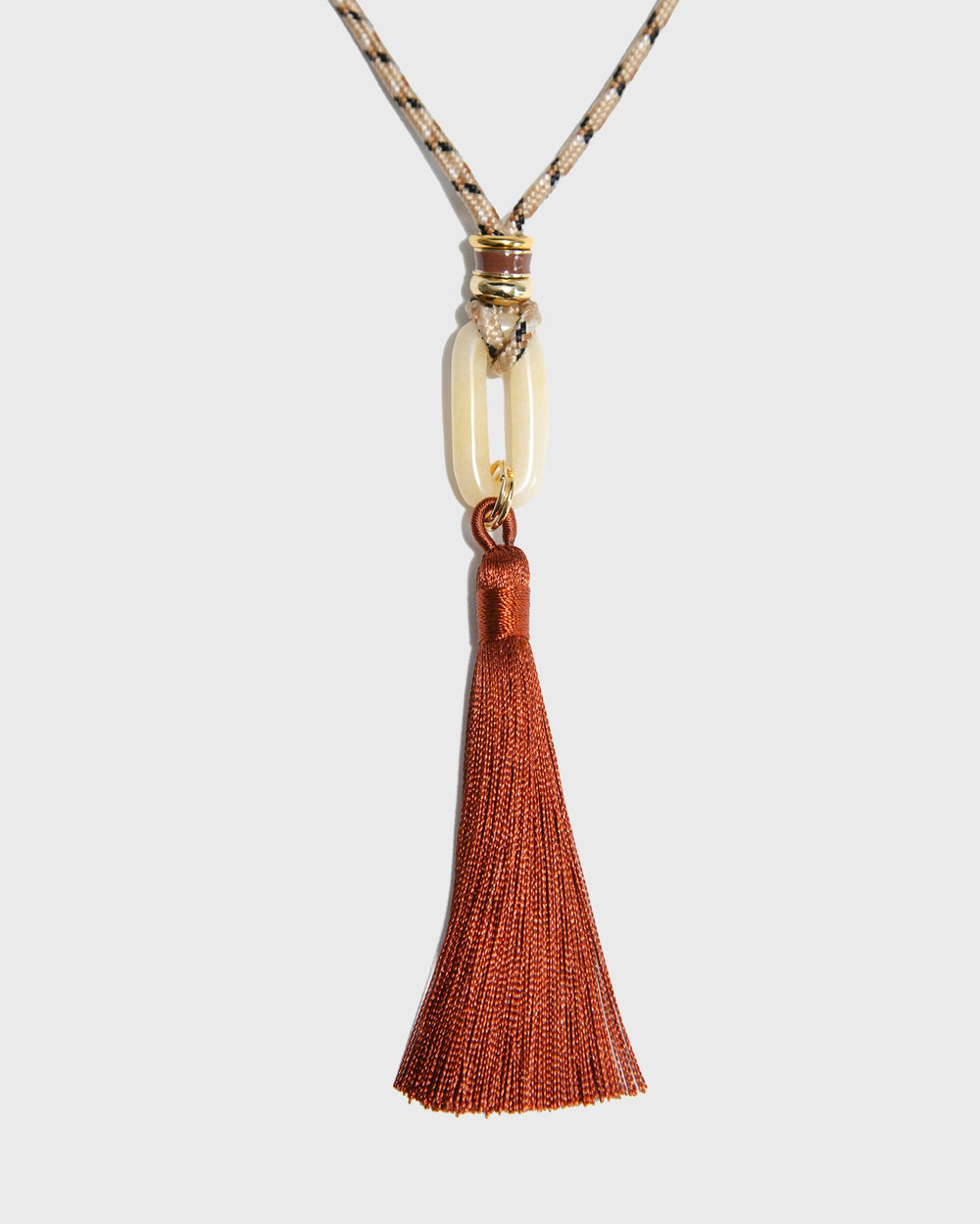 Necklace with a tassel pendant on a light gray background