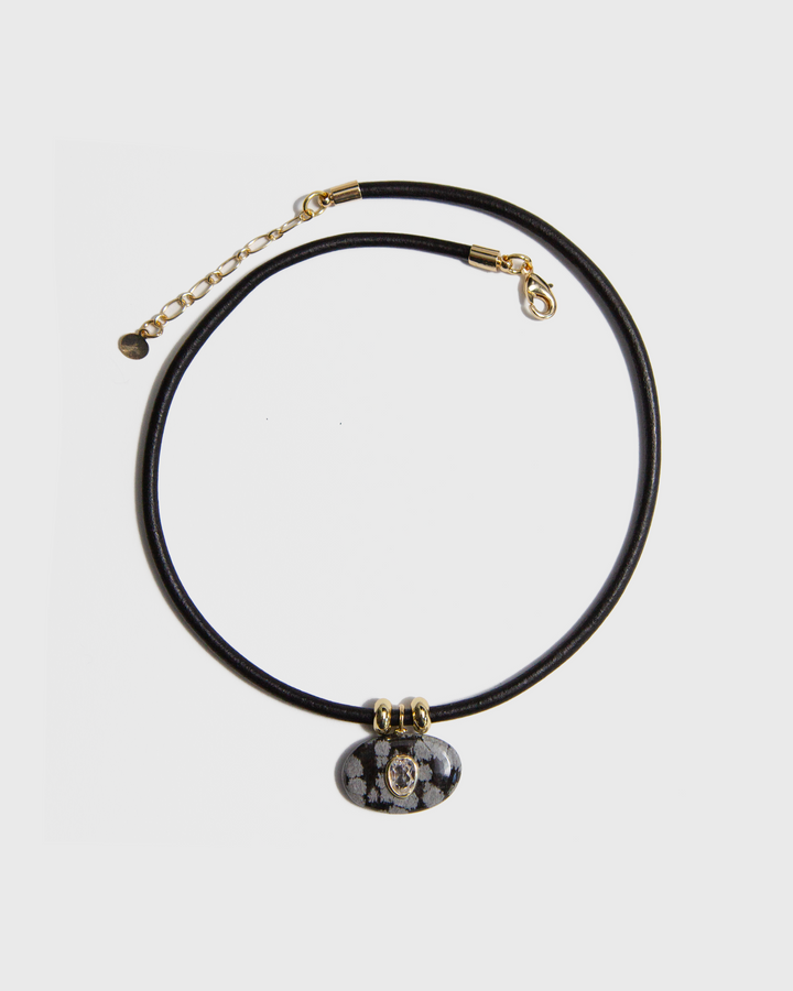 Necklace with a black cord and decorative pendant on a light grey background