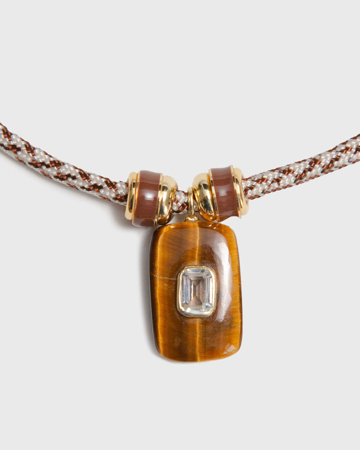 Necklace with a brown pendant featuring a central gemstone on a light grey background
