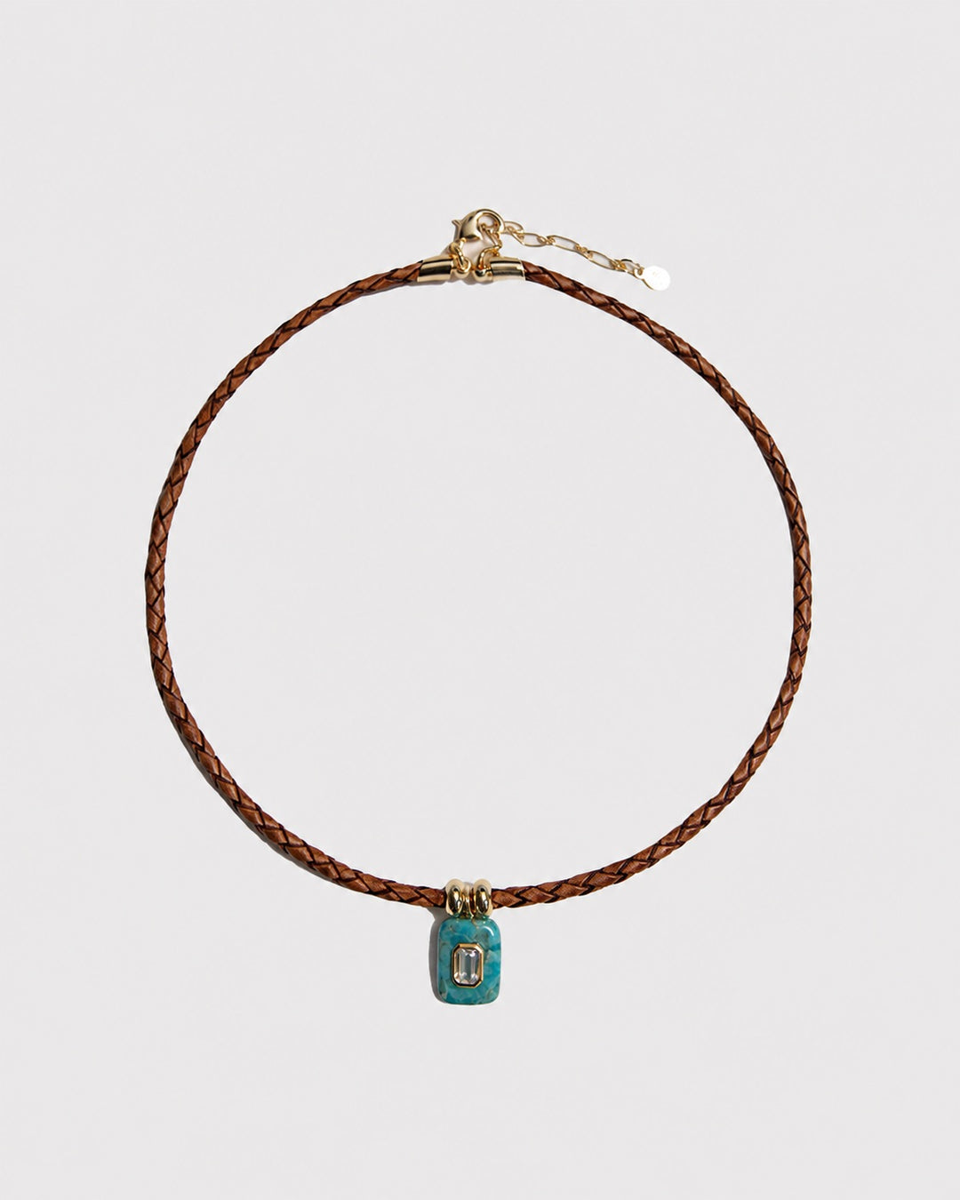 Necklace with a turquoise pendant on a light grey background