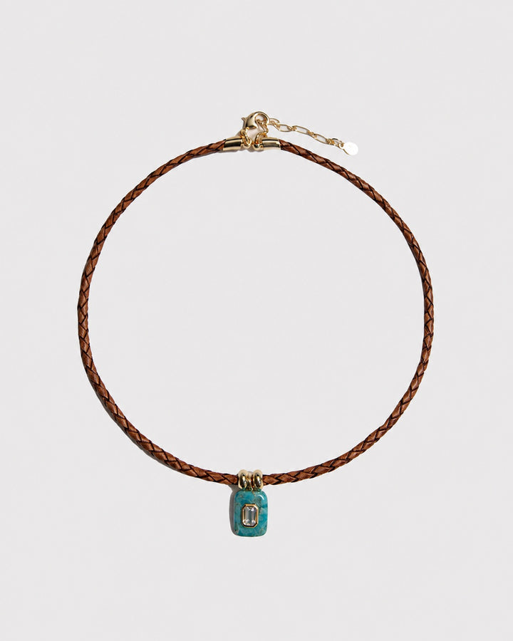 Necklace with a turquoise pendant on a light grey background